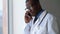 Doctor in uniform coat talk on phone in workplace hospital. Male worker communicate, solving