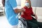 Doctor in uniform holds hand of sick young woman in wheelchair portrait