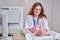 The doctor uses a syringe to inject a newborn child. A nurse in uniform is preparing to vaccinate a child