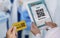 Doctor using tablet computer to scan QR code from medication car