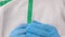 Doctor virologist scientist hand in blue gloves holding vaccine ampoule, syringe injection, medicine drug close-up