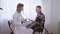 Doctor visit, medical worker measures the pressure of a man in a wheelchair, taking care of patient