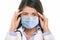 Doctor wearing coronavirus surgical face mask in panic scared doing a funny stressed out facial expression holding head