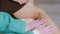 A doctor wearing medical gloves examines the bruise on the inside of the patient's female knee and the injuries