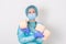 Doctor wearing PPE protection suite or nurse with a stethoscope holds a rolls of toilet paper. Lack of toilet paper in the