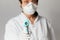 Doctor wearing a respirator N95 mask to use infrared forehead thermometer  to check body temperature for virus symptoms.  Respirat