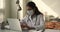 Doctor wearing white coat facemask working on laptop at workplace