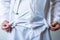 Doctor, wearing white lab coat with stethoscope around his neck, showing empty robe pockets  without money. Concept photo small s