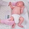 The doctor weighs a newborn baby on a scale. Uniformed nurse taking measurements of the child weight