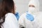 Doctor in white antiplague suit takes swab from his throat with cotton swab into test tube in apartment