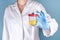 A doctor in a white coat and blue gloves holds a plastic can of urine in hand. urine tests for virus, alcohol, diseases