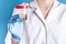A doctor in a white coat and blue gloves holds a plastic can of urine in his hand. urine tests for virus and diseases