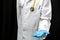 A doctor in a white coat holds a pill in his hand on a black background. Medical preparations for the treatment of coronavirus. A
