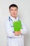 A doctor in a white coat with a stethoscope on his neck holds a green folder in his hands. One on a white background