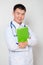 A doctor in a white coat with a stethoscope on his neck holds a green folder in his hands. One on a white background