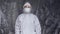 Doctor in white protective suit, mask, glasses and rubber gloves is ready for helping a people while coronavirus