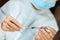 Doctor in a white surgical gown and blue mask holds in hands a medical syringe and bottle with insulin for diabetes. Sugar