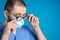 Doctor wiping foggy glasses caused by wearing disposable mask on background. Protective measure during coronavirus pandemic