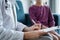 Doctor woman and kid patient at home. The pediatrician fills up medical form, close up. Medicine, healthcare concepts