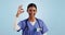 Doctor, woman and okay hands of healthcare success, support and excellence in services on a blue background. Happy face