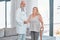 Doctor, woman and walking stick in portrait for rehabilitation, healthcare or wellness in consultation room. Medic