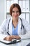 Doctor woman at work. Physician filling up medical history records form at the desk. Medicine, healthcare concept