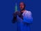 Doctor working in a lab concept. Male healthcare specialist holding glass flask with green glowing liquid in a blue lab room.