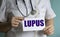 Doctor writing word lupus with marker. Medical concept