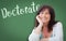 Doctorate Written On Green Chalkboard Behind Smiling Woman