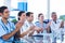 Doctors applauding while sitting at a table