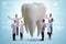 Doctors examining giant tooth in dental concept