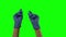 Doctors female hands in blue gloves are clicking fingers, waving index fingers. Green screen. Close up