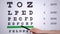 Doctors hand showing letters on eye chart, planned health examination, vision