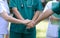 Doctors and nurses in a medical team stacking hands outdoor on t