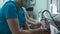 Doctors surgeon in robe washes hands in washbasin before surgery