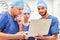 Doctors on surgery team look at laptop together