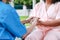 Doctors wearing surgical gowns, holding hands, elderly patients sitting in wheelchairs encouraging