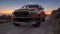 Dodge RAM 1500 driving a scenic road by the sea during a beautiful sunrise