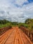 Dodgy wooden bridge with timber planks and old iron rails crossing river in Gabon, Central Africa