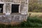 Doe Deer next to a barn in the grass