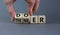 Doer or thinker symbol. Concept words Doer or thinker on wooden cubes. Businessman hand. Beautiful grey table grey background.