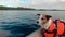 Dog in the boat. Jack russell terrier in a life jacket on the lake