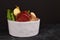 Dog bowl filled with mixture of biologically appropriate raw food containing meat chunks, fish, fruits and vegetables