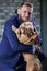 Dog bulli and her owner, her loving master who holds the dog in her arms, hugs and kisses. The dog feels good on the