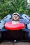A dog in a captain`s cap sits in a boat in an inflatable ring. safety. summer rest