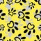 Dog or cat paws traces seamless pattern. Grey stamps on yellow background. Silhouettes of cat, dog footprint. For logo