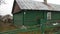 Dog on a chain in the yard near a house in the countryside. Green house. panorama. 4k