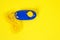 Dog clicker  positive reinforcement training tool for dogs on yellow background. Clicker used for animal training or education