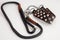 Dog collar from brown leather with metal rivets, black and ginger leash, carabiner fastened . Close up, white background, copy spa