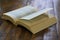 Dog eared paperback book on worn wooden surface